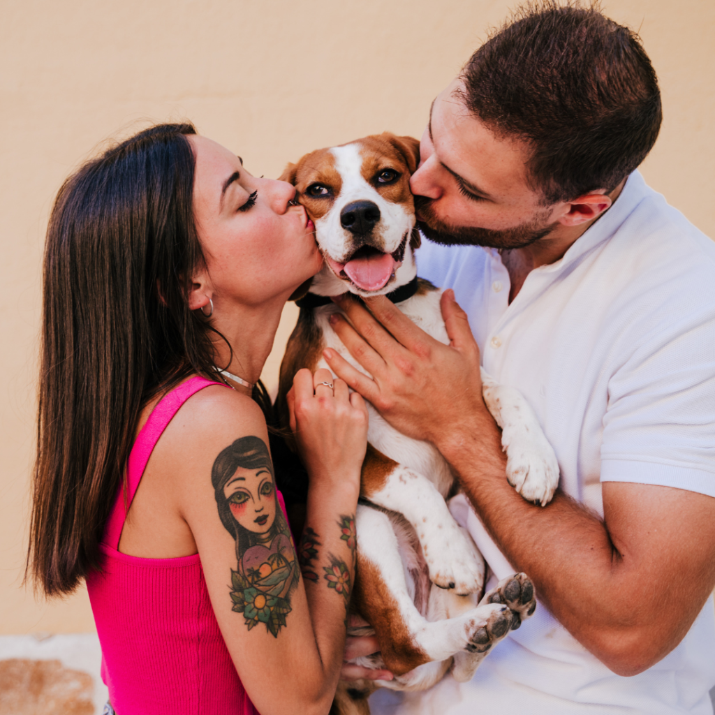 pareja de hombre y ujer que besan su beagle